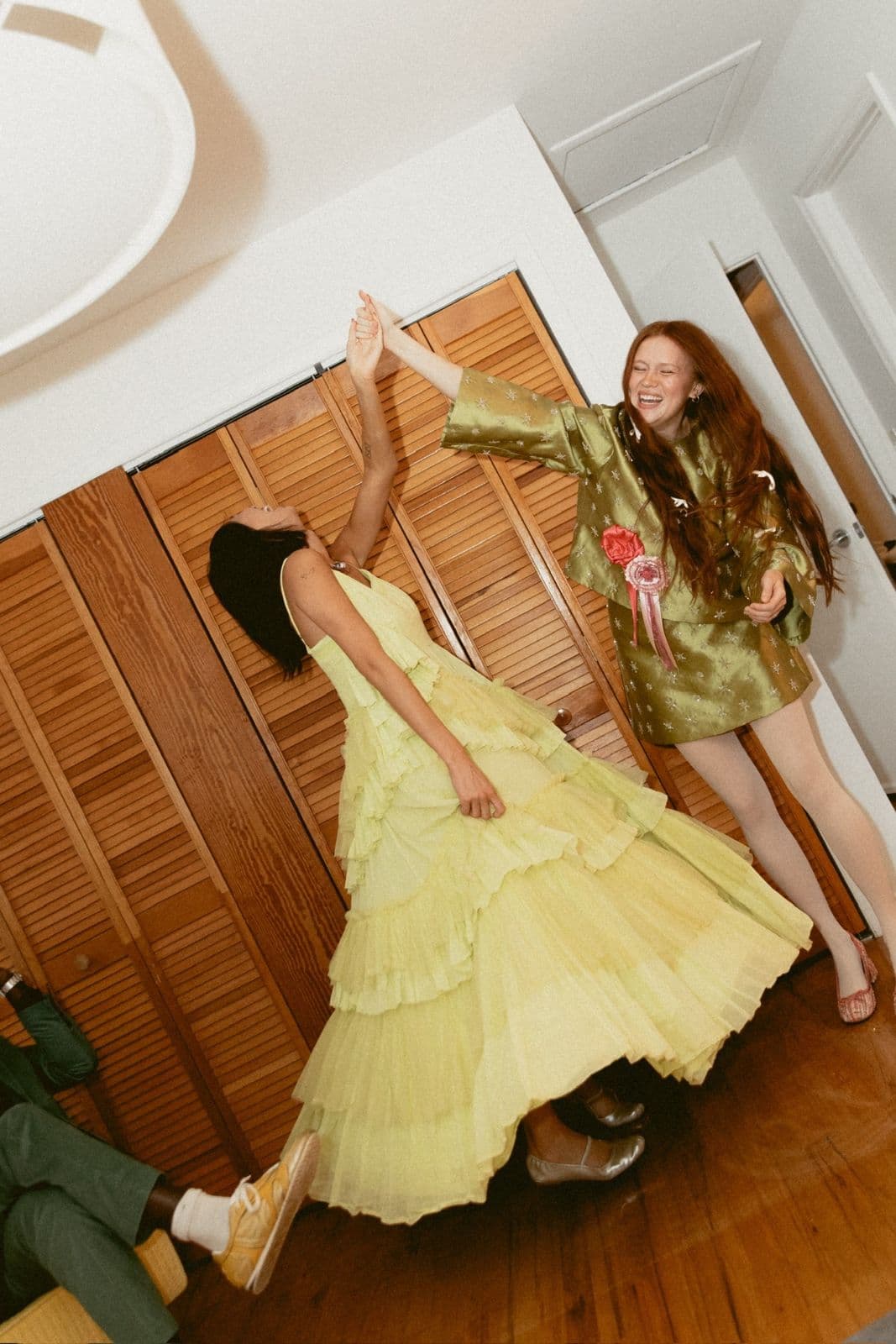 Two models dancing in front of the wood slat closet doors